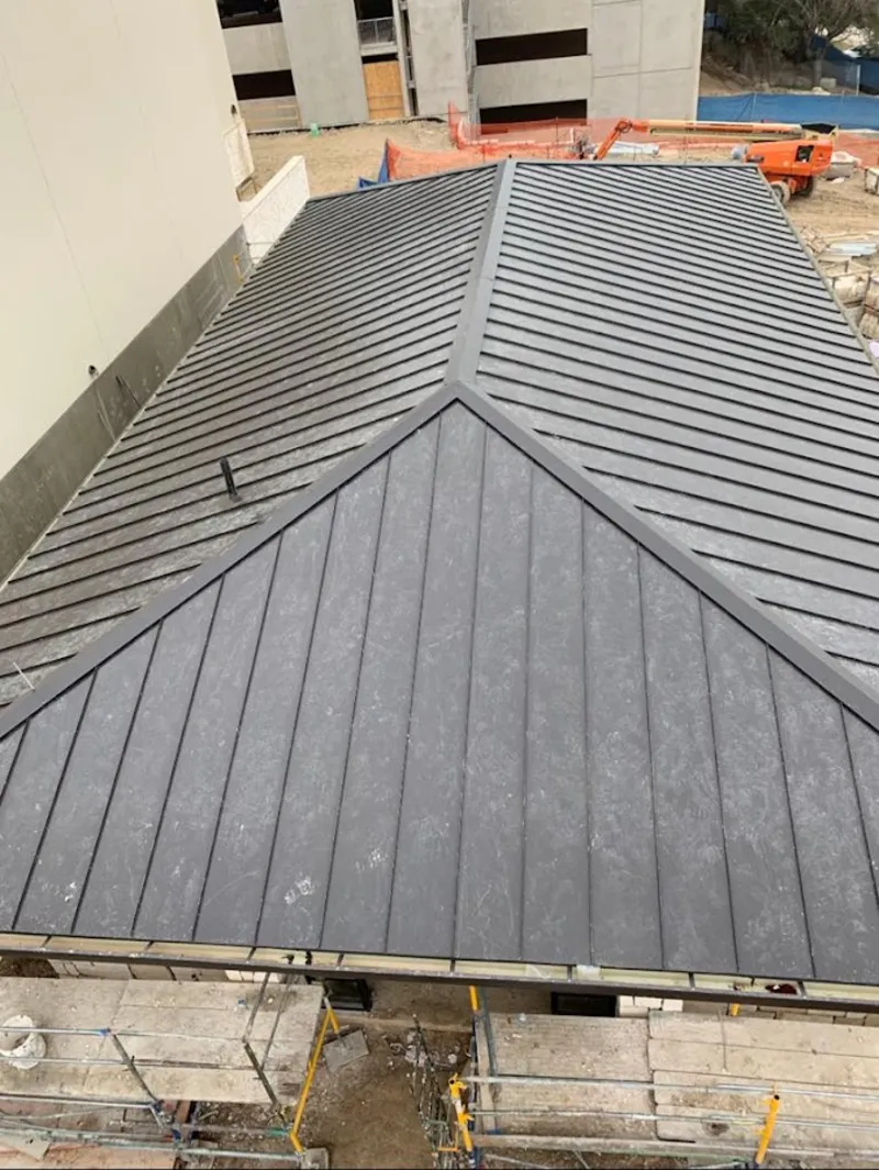 Commercial metal roof construction with crane equipment in Clyde